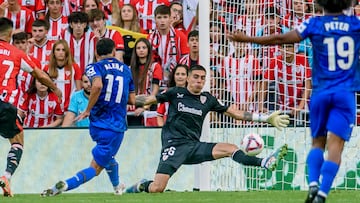 BILBAO, 15/08/2024.- El portero del Athletic Club de Bilbao Alex Padilla (c) realiza una parada a tiro del centrocampista del Getafe CF Carles Aleñá (i), durante el partido de Liga en Primera División que disputan este jueves en el estadio de San Mamés, en Bilbao. EFE/ Javier Zorrilla
